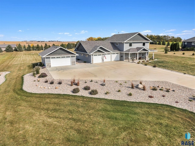 craftsman-style home with a rural view, a garage, and a front lawn