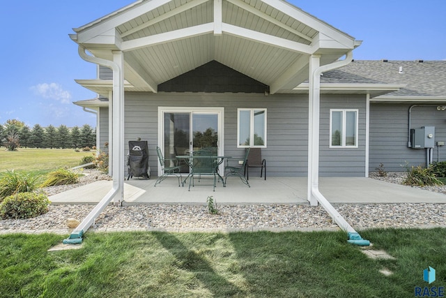 rear view of house with a patio and a lawn