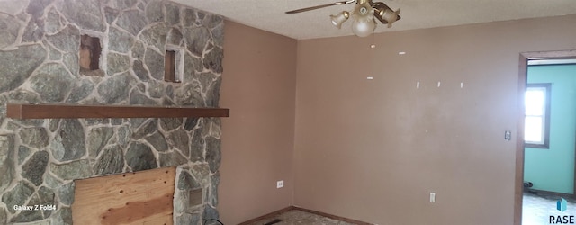 living room featuring ceiling fan and a textured ceiling