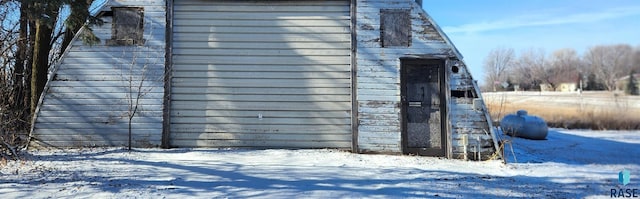 snow covered property with an outdoor structure