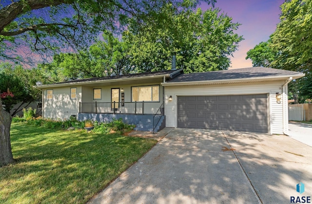 single story home with a garage and a yard