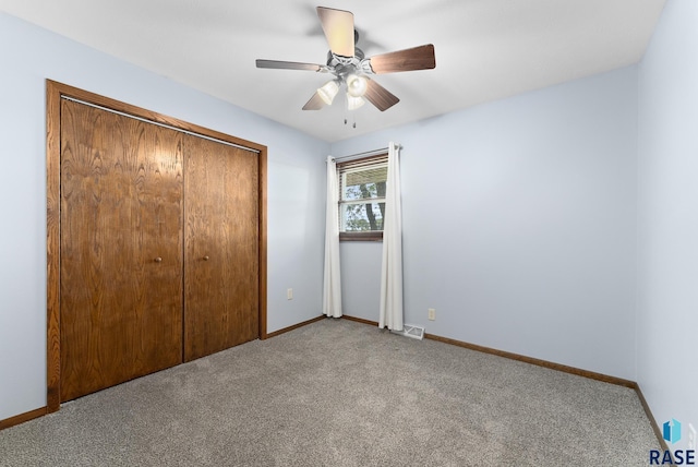 unfurnished bedroom with ceiling fan, light colored carpet, and a closet