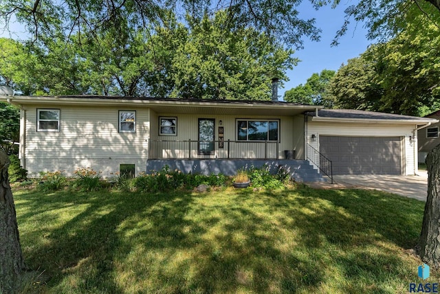 view of front of property featuring a garage, covered porch, and a front yard