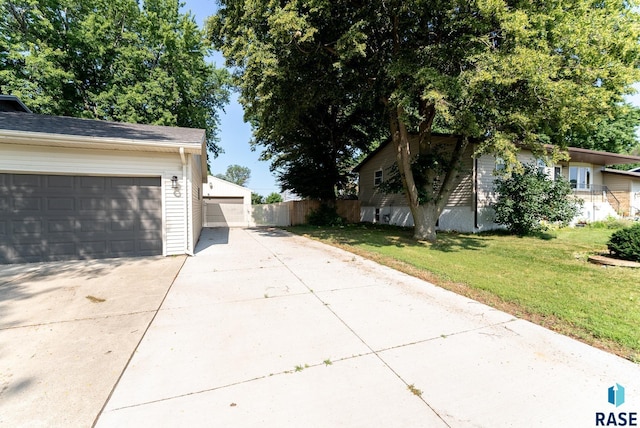 view of side of property featuring a garage and a yard