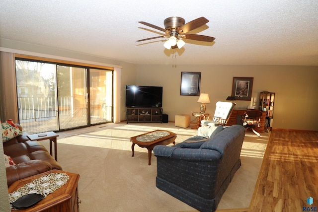 carpeted living room with ceiling fan and a textured ceiling