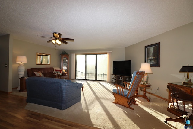 living room with hardwood / wood-style flooring, ceiling fan, and a textured ceiling