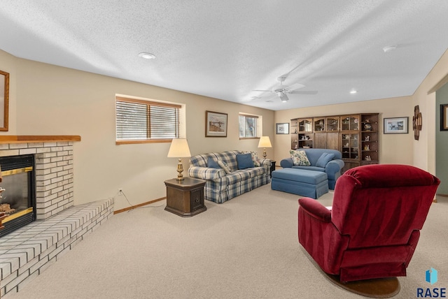 carpeted living room featuring ceiling fan, a brick fireplace, and a textured ceiling