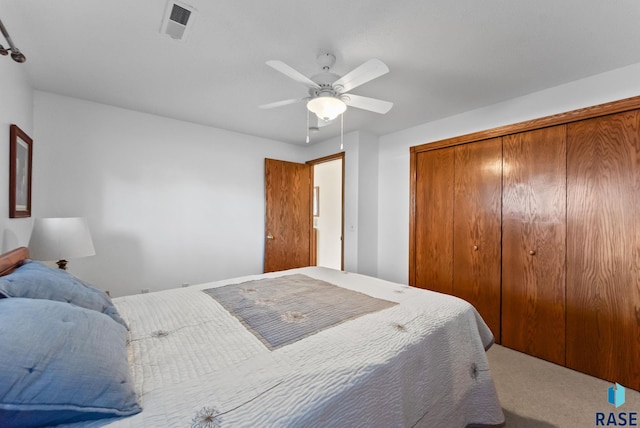 carpeted bedroom with ceiling fan and a closet