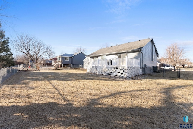 back of house with a wooden deck and a lawn