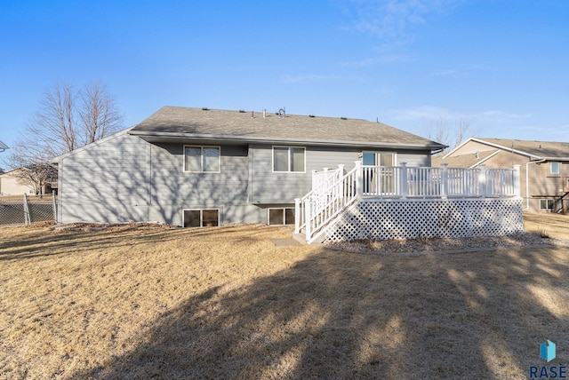 rear view of house featuring a deck and a lawn