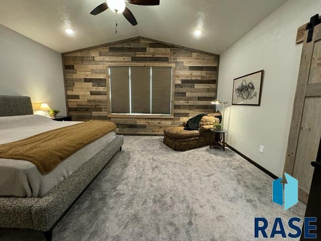 carpeted bedroom featuring vaulted ceiling, a barn door, ceiling fan, and wooden walls