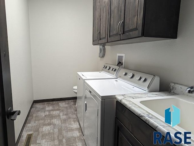 washroom with cabinets and washer and dryer