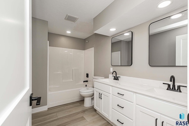 full bathroom with vanity, hardwood / wood-style floors, bathing tub / shower combination, and toilet