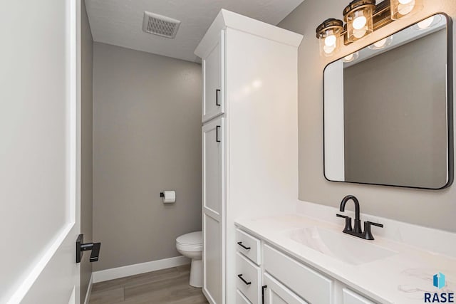 bathroom featuring hardwood / wood-style flooring, vanity, and toilet