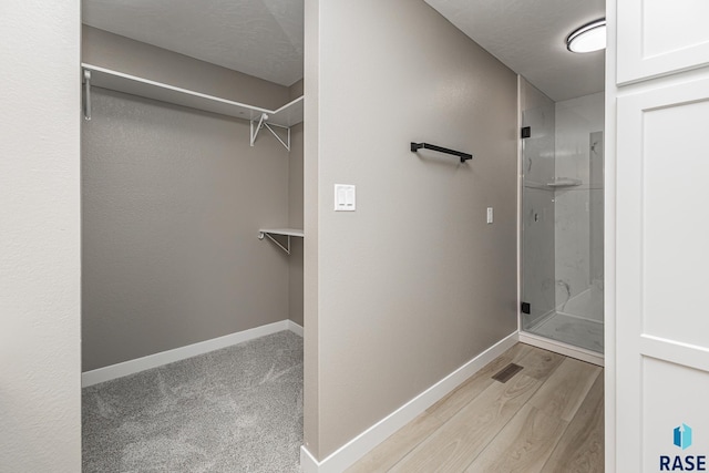 bathroom featuring wood-type flooring and walk in shower