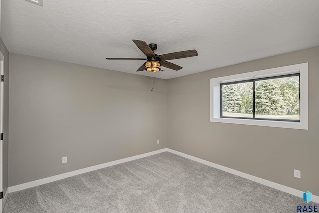 unfurnished room with ceiling fan, carpet, and a textured ceiling