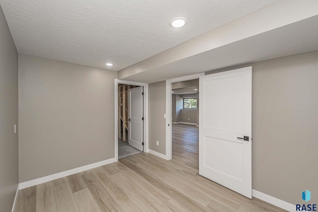 empty room featuring a textured ceiling and light wood-type flooring