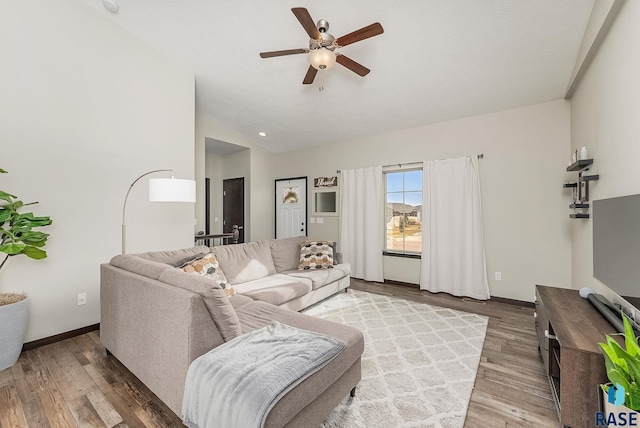 living room with lofted ceiling, hardwood / wood-style flooring, and ceiling fan