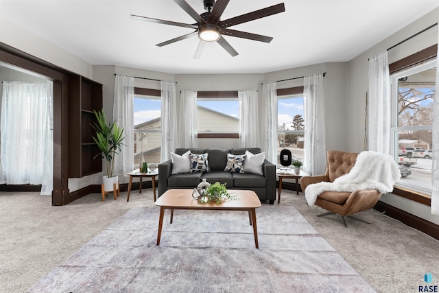 carpeted living room with ceiling fan