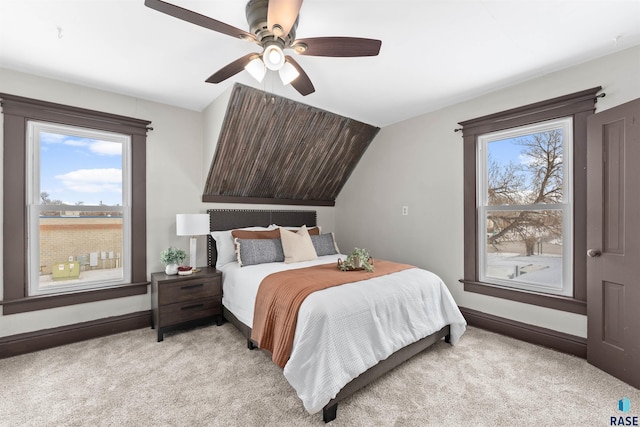 bedroom with lofted ceiling, light carpet, and multiple windows