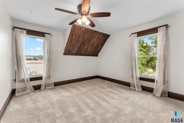 additional living space featuring ceiling fan, vaulted ceiling, and light carpet