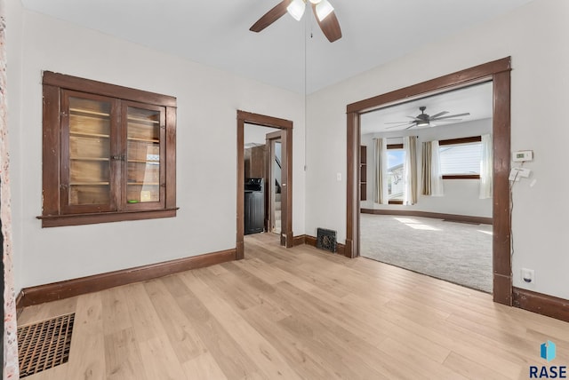 spare room with ceiling fan and light wood-type flooring