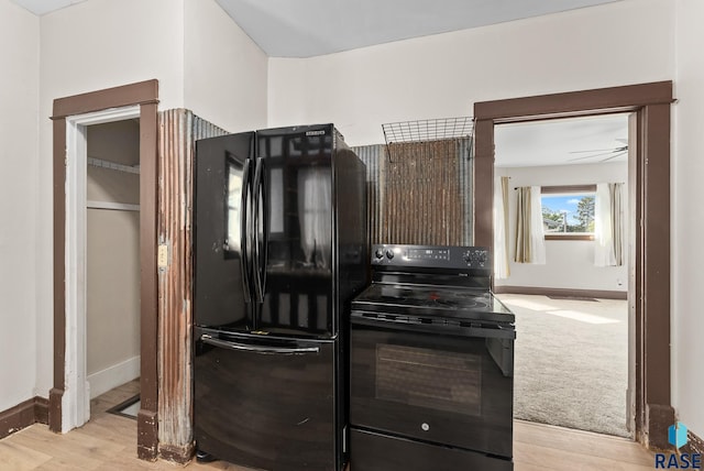 kitchen with dark brown cabinetry, black appliances, and light wood-type flooring