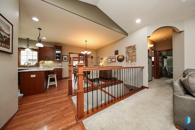 interior space with an inviting chandelier, vaulted ceiling, and wood-type flooring