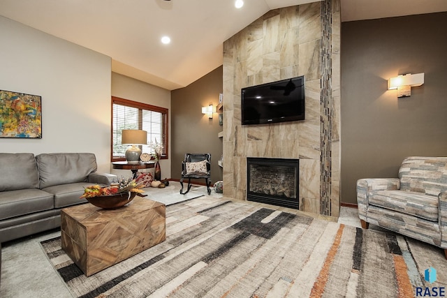 carpeted living room with a tile fireplace and vaulted ceiling