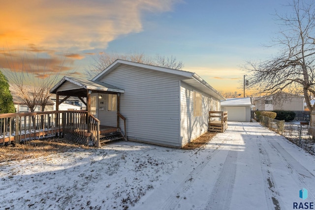 view of front of house with a wooden deck and a storage shed