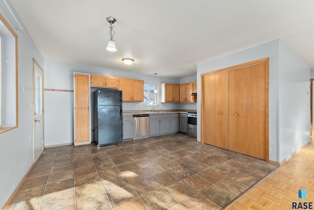 kitchen featuring hanging light fixtures, stainless steel appliances, sink, and a textured ceiling