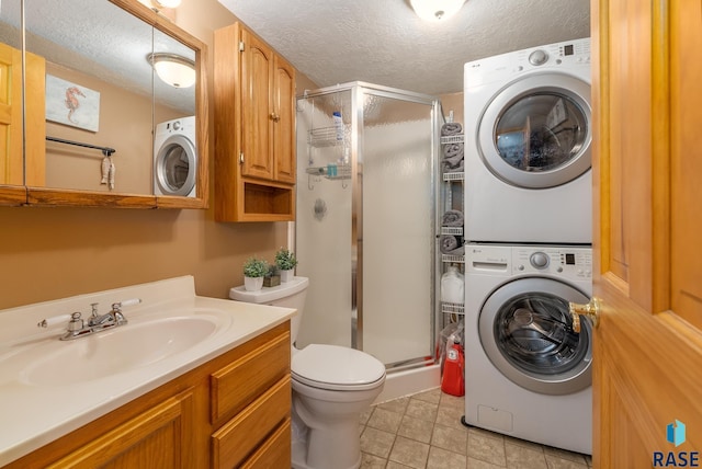 laundry area with stacked washer / dryer, sink, and a textured ceiling