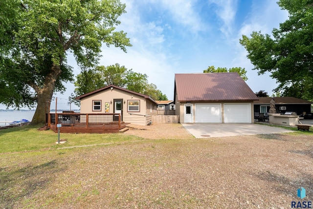 view of front of house featuring a garage, a wooden deck, and a front yard