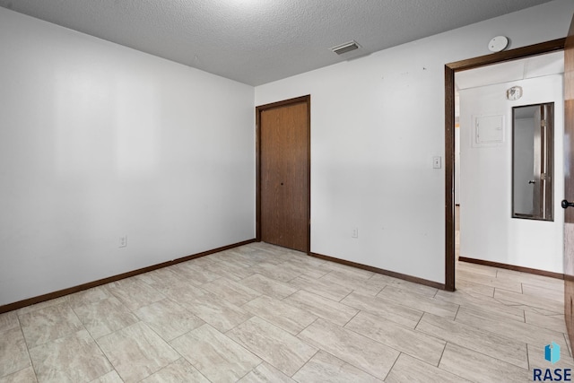 unfurnished room featuring a textured ceiling