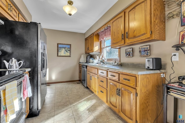 kitchen with appliances with stainless steel finishes, sink, and light tile patterned floors