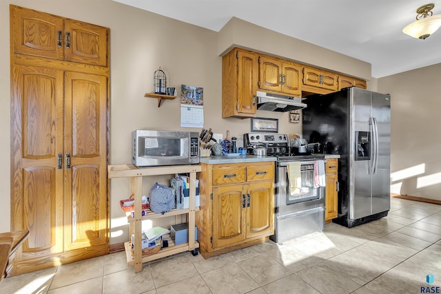 kitchen featuring stainless steel appliances, range hood, and light tile patterned floors