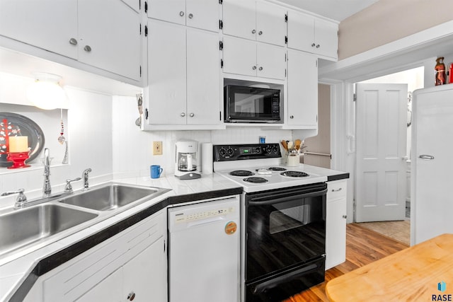 kitchen featuring range with electric stovetop, tile countertops, black microwave, white cabinetry, and white dishwasher