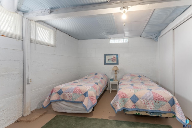 bedroom featuring concrete flooring and a closet