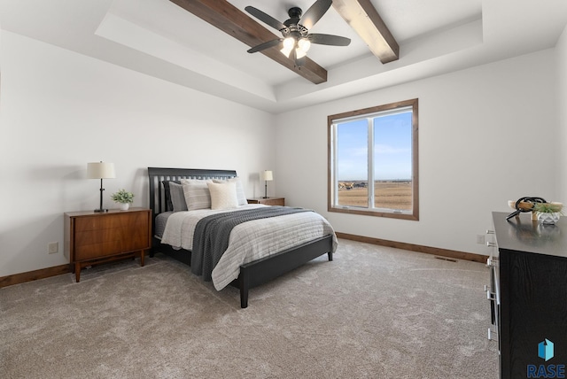 bedroom featuring ceiling fan, light carpet, beam ceiling, and a tray ceiling