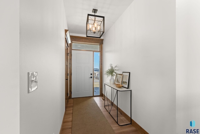 doorway to outside featuring an inviting chandelier and light wood-type flooring