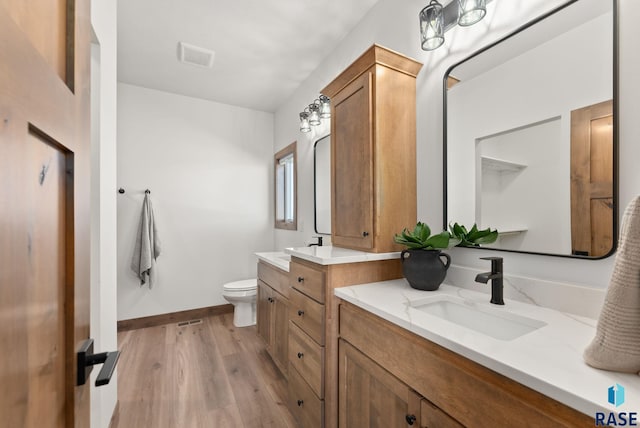 bathroom featuring vanity, hardwood / wood-style floors, and toilet