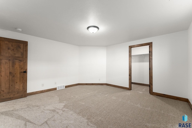 unfurnished bedroom featuring a walk in closet and carpet floors