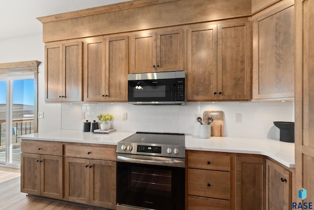 kitchen featuring decorative backsplash, stainless steel appliances, and light hardwood / wood-style floors