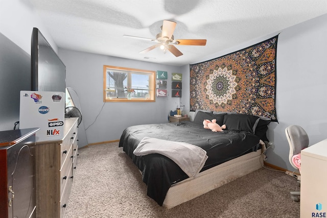 bedroom featuring ceiling fan, light colored carpet, and a textured ceiling