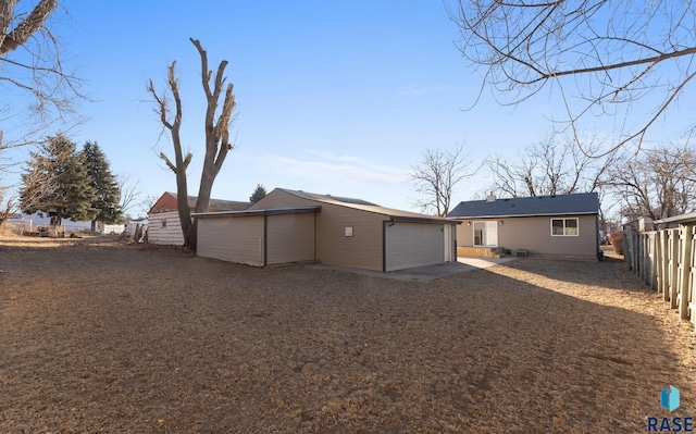 back of house with a garage and an outdoor structure