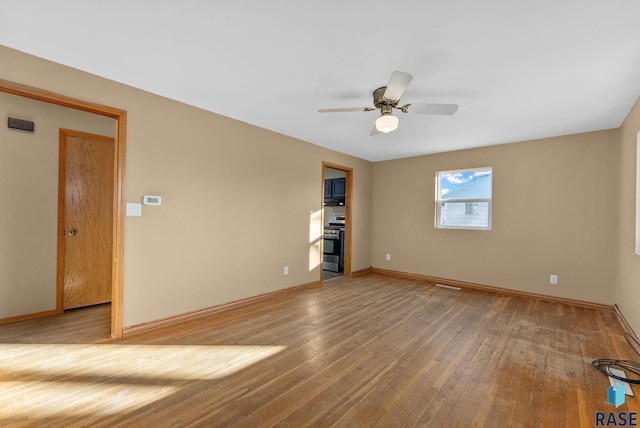 empty room with hardwood / wood-style flooring and ceiling fan