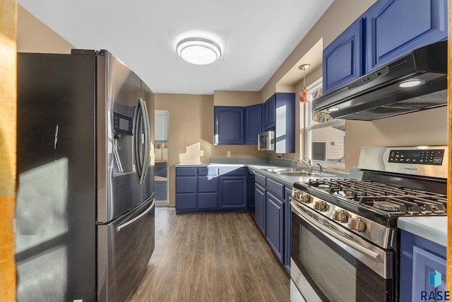 kitchen with blue cabinetry, sink, hanging light fixtures, appliances with stainless steel finishes, and dark hardwood / wood-style flooring