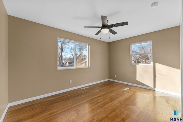 spare room with hardwood / wood-style flooring, plenty of natural light, and ceiling fan