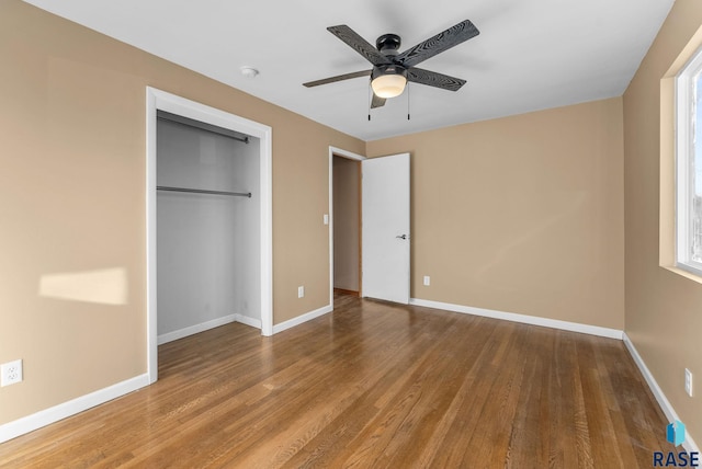 unfurnished bedroom with wood-type flooring, a closet, and ceiling fan