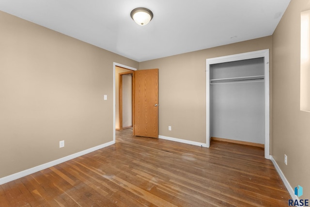 unfurnished bedroom featuring wood-type flooring and a closet